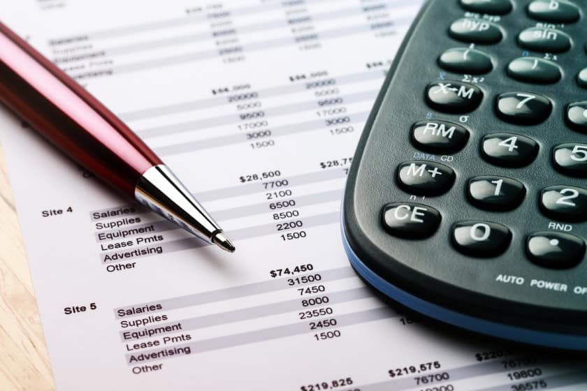 pen and calculator sitting on top of documents related to tax