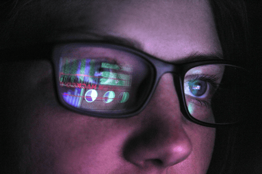 Reflection of lines of code and data on glasses worn by a person