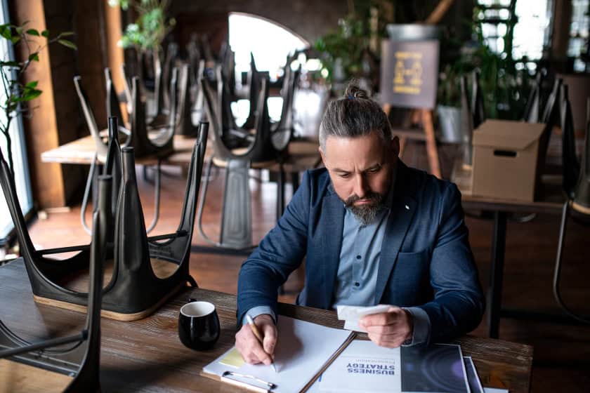 Frustrated restaurant manager looking at sheets of paper